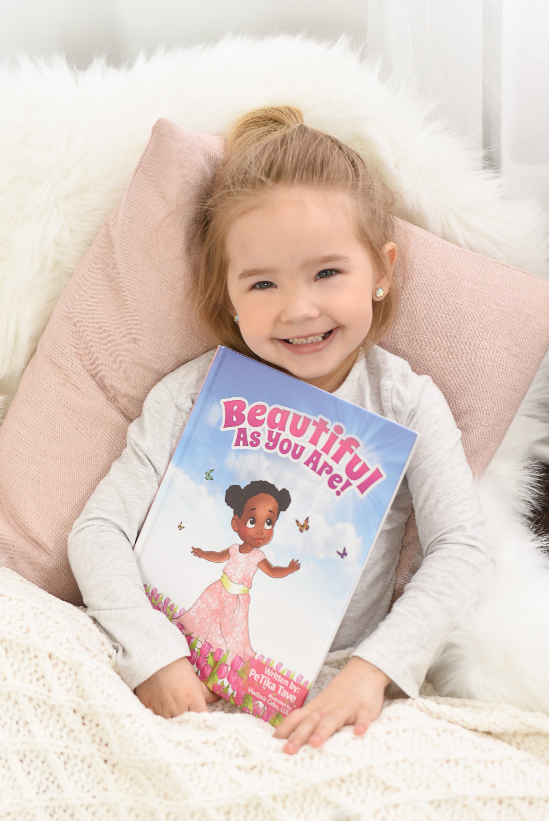 Picture of Beautiful As You Are picture book with a little girl holding it. 